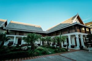 un edificio con palmeras delante en Houngvilai Hotel en Luang Prabang