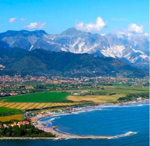 eine Luftansicht auf eine Stadt und das Meer mit Bergen in der Unterkunft CASA GILIANA al mare in Fiumaretta di Ameglia