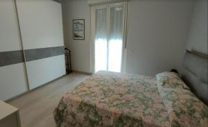 ein Schlafzimmer mit einem Bett und einem großen Fenster in der Unterkunft CASA GILIANA al mare in Fiumaretta di Ameglia
