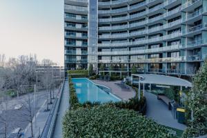 an apartment complex with a swimming pool and a building at Central Located 2-Bed with Pool, Gym & Parking in Canberra