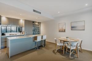 a kitchen and dining room with a table and chairs at Central Located 2-Bed with Pool, Gym & Parking in Canberra