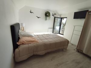 Ένα ή περισσότερα κρεβάτια σε δωμάτιο στο Petit gîte bleu