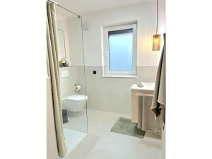 uma casa de banho branca com um WC e uma janela em Holiday room Three - Countries - Harmony em Mettlach