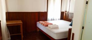 um pequeno quarto com uma cama e uma janela em Bon Tai Oasis Bungalows em Muang Không