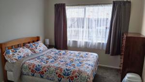 1 dormitorio con cama y ventana en Bowmont, en Invercargill