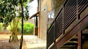 a brick building with a door and a tree at Clayfingers Art Cottage in Trichūr