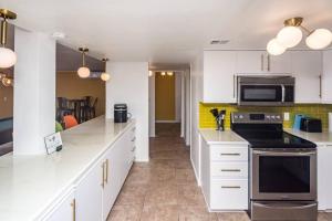 een keuken met witte kasten en een fornuis met oven bij Bella Cactus - Palm Springs Vibes Pool & Spa in Lake Havasu City