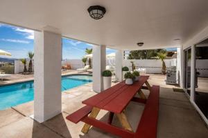 een rode picknicktafel op een patio naast een zwembad bij Bella Cactus - Palm Springs Vibes Pool & Spa in Lake Havasu City