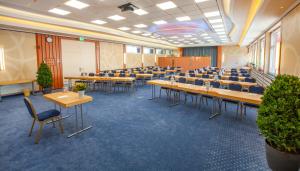 una grande stanza con tavoli e sedie di Hotel Hochsauerland 2010 a Willingen