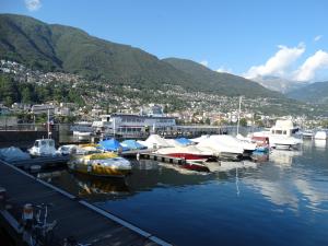 a bunch of boats docked in a marina with a city at Hotel Excelsior in Locarno