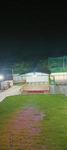 a tennis court with a net in a grass field at HSV WONDER WORLD,FARM HOUSES in Venkatāpur