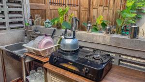 uma cozinha com uma chaleira de chá e um fogão em Yukke Tembi Homestay em Yogyakarta
