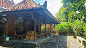 a gazebo with chairs and tables in a yard at Yukke Tembi Homestay in Yogyakarta