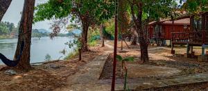 a building next to a river with trees at Bon Tai Oasis Bungalows in Muang Không