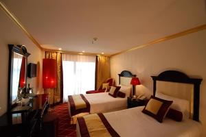 a hotel room with two beds and a window at Super Nile Cruise LUXOR & ASWAN in Luxor