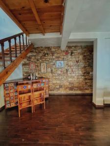 Habitación con pared de ladrillo y mesa de madera. en Panorama by Meraki - Entire villa with Himalayan View en Rānīkhet