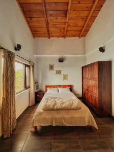 1 dormitorio con cama grande y ventana grande en Panorama by Meraki - Entire villa with Himalayan View en Rānīkhet