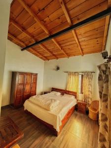 1 dormitorio con cama y techo de madera en Panorama by Meraki - Entire villa with Himalayan View en Rānīkhet