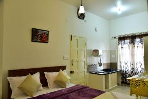 a bedroom with a bed and a small kitchen at Coorg Lotus Villa in Madikeri