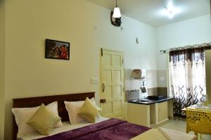 a bedroom with a bed and a table and a window at Coorg Lotus Villa in Madikeri