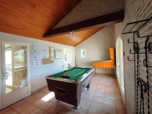 a room with a pool table and an orange bench at O'gîte Bleu pour 14 personnes in Huillé