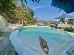 a swimming pool with a person in the water at Airam, Holistic Boutique Hotel in Tequesquitengo