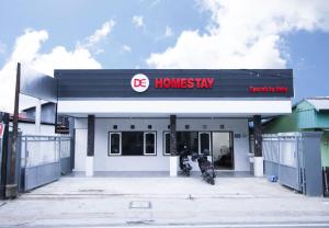 ein Gebäude mit einem Motorrad, das davor geparkt ist in der Unterkunft DE Homestay Banjarmasin in Benuaanyar