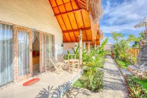 una casa con un ampio patio con tavolo e sedie di Cassava Penida Cottage a Nusa Penida