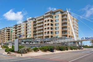 a large apartment building with a walkway in front of it at Glenelg Beachfront Luxury Apartment in Glenelg