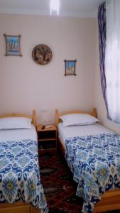 a bedroom with two beds and a window at Guest House "AN" & Teahouse in Bukhara