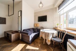 a living room with a couch and a table at Baltic Design Apartments with free Parking in Rīga
