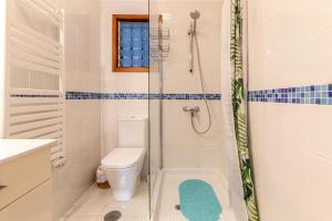 La salle de bains blanche est pourvue d'une douche et de toilettes. dans l'établissement Cliff View Terrace by Dream Homes Tenerife, à Puerto de Santiago