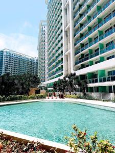 ein großer Pool mit Wasser vor einigen Gebäuden in der Unterkunft Azure Residences Sumerton Staycation in Manila