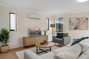 a living room with a couch and a tv at Comfy 2-Bedroom Family Apartment with Free Parking in Brisbane