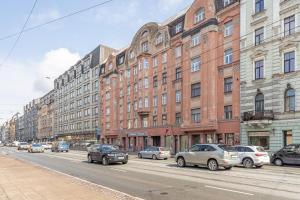 una calle de la ciudad con coches estacionados frente a los edificios en Baltic Design Apartments with free Parking en Riga
