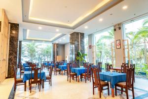a dining room with blue tables and chairs at Ocean Waves Resort Cam Ranh in Cam Lâm