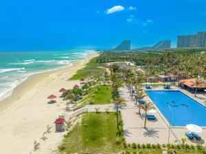 Cam LâmにあるOcean Waves Resort Cam Ranhのスイミングプールとビーチのあるリゾートの空からの景色を望めます。