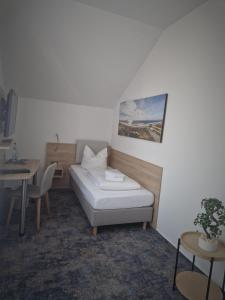 Zimmer mit einem Bett, einem Tisch und einem Tisch in der Unterkunft Villa Ludwigsburg in Kühlungsborn