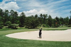 a man standing on a sand mound on a golf course at Lodge Kent in Hokuto