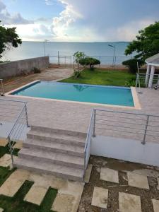 a swimming pool with stairs next to the ocean at Beachscape At Black River Ethlyn by the sea in Black River