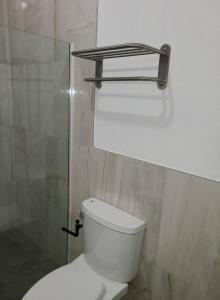 Baño con aseo y estante encima en Beachscape At Black River Ethlyn by the sea, en Black River