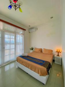 una camera con un letto in una stanza con finestre di Rumah palala a Kampungdurian