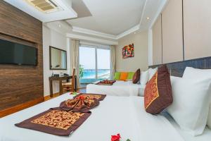 a hotel room with a bed and a flat screen tv at Ocean Waves Resort Cam Ranh in Cam Lâm