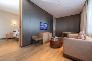 Televiisor ja/või meelelahutuskeskus majutusasutuses Merlinhood Hotel Guangzhou Xiajiao Metro Station Shaxi International Hotel Supplies City