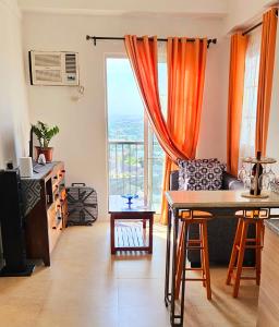 a living room with a table and a large window at AppleOne CondoTower1-1055 in Cebu City