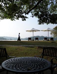 a table and benches with umbrellas in a park at Heavensa Luxury Villas in Galle