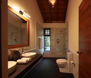 a bathroom with two sinks and a toilet and a shower at Heavensa Luxury Villas in Galle