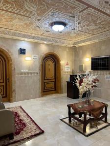 a lobby with a table with flowers on it at دار اليقين in Al Madinah