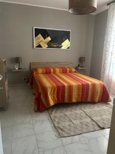 - une chambre avec un lit et une couette colorée dans l'établissement Casa della Vacanza a Catania - Acicastello, à Aci Castello