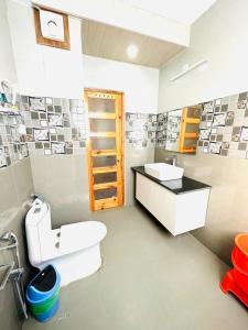 a bathroom with a white toilet and a sink at Vista Resort - Managed BY The Four Season, Close to Manali Mall Road in Manāli